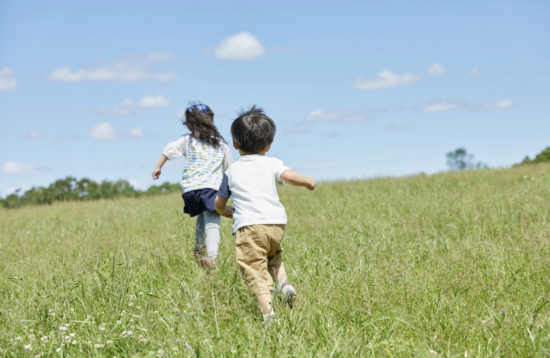 草原を一緒に走る2人の子ども